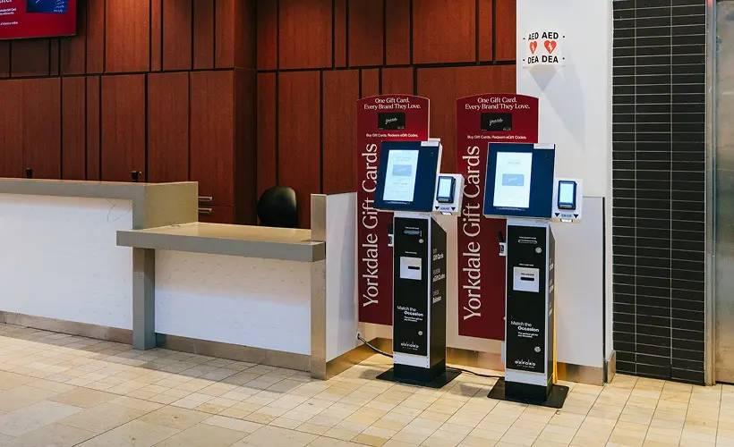 Two Yorkdale Gift Card self-serve kiosks beside the Guest Services counter