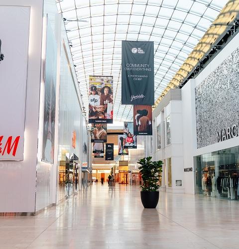Yorkdale mall corridor with H&M and Marciano stores and community campaign banners