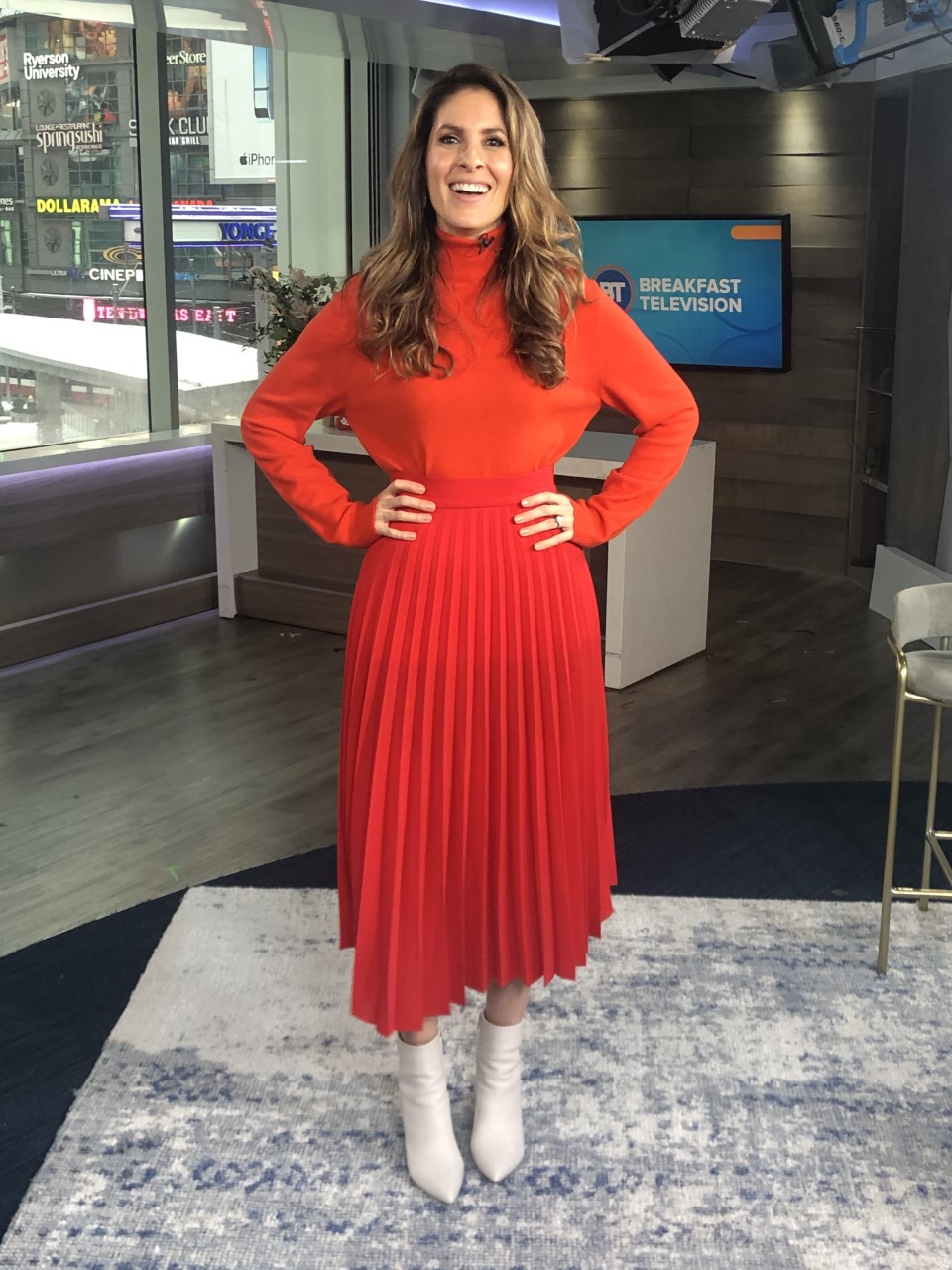 Dina wearing all red ensemble with white pointy boots