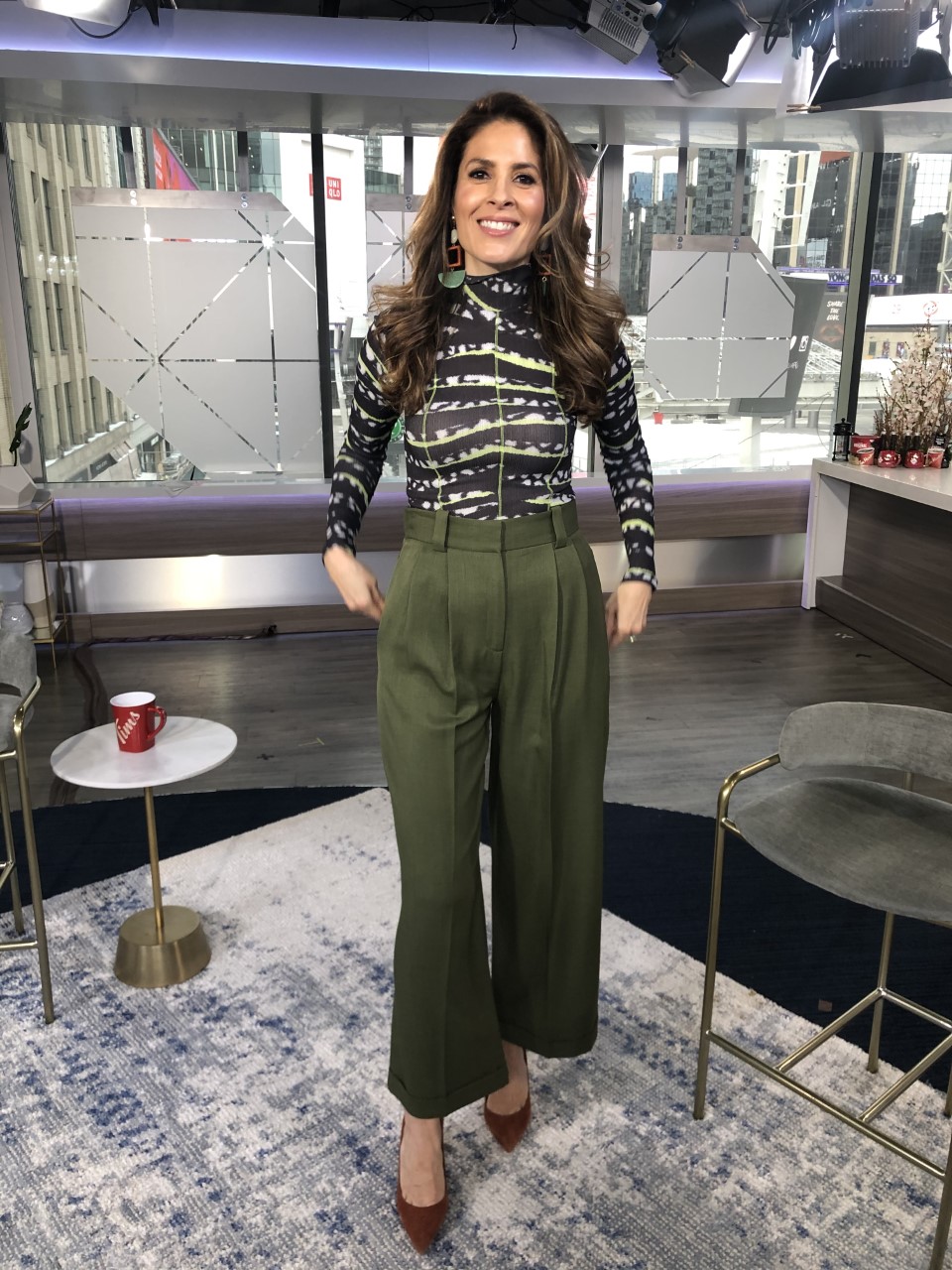 Dina wearing army green wide leg trousers with black and white top