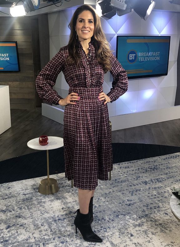 Dina wearing muted plaid dress with black pointy boots