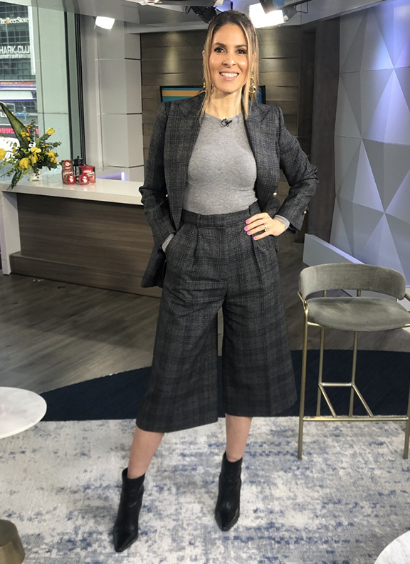 Dina wearing patterned blazer and knee length pants with black booties