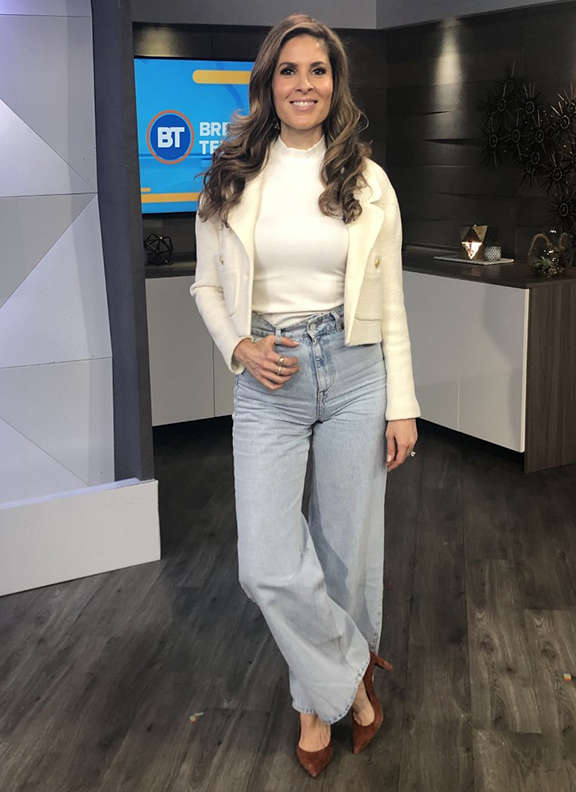 Dina wearing white top and jacket paired with light jeans bell bottoms