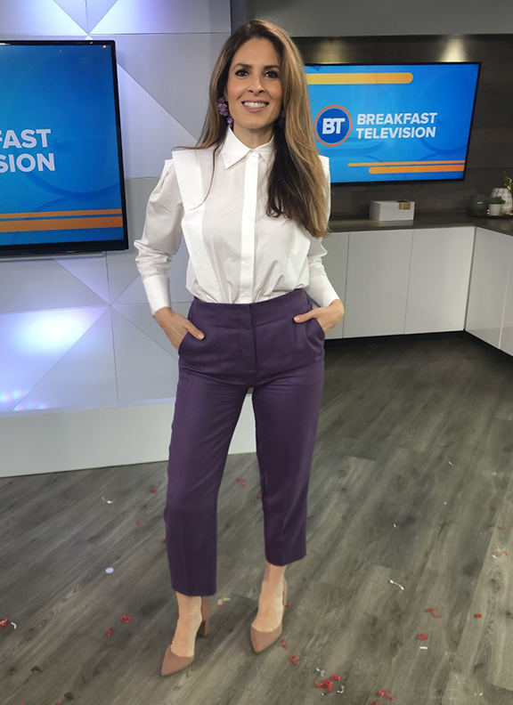 Dina wearing muted purple dress pants with white blouse
