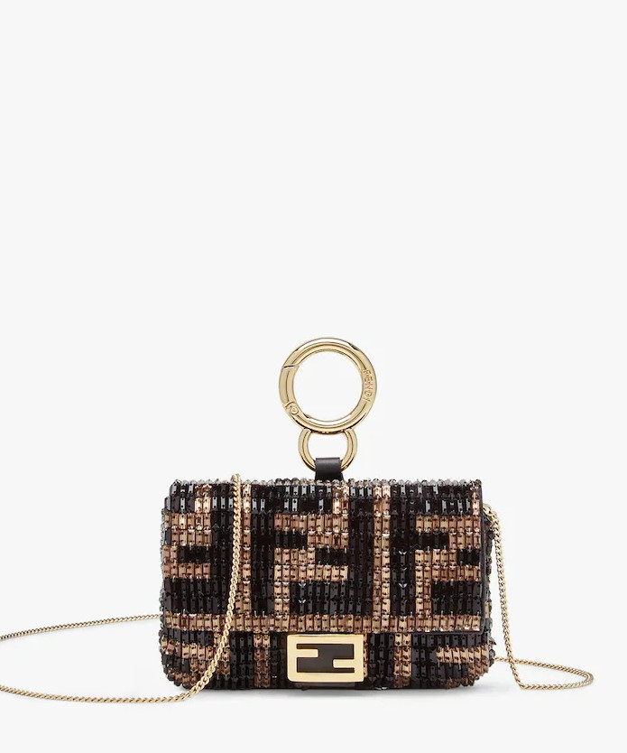 Image of a sequinned Fendi nano baguette charm in the classic Fendi monogram print. there is gold harware and a gold chain.