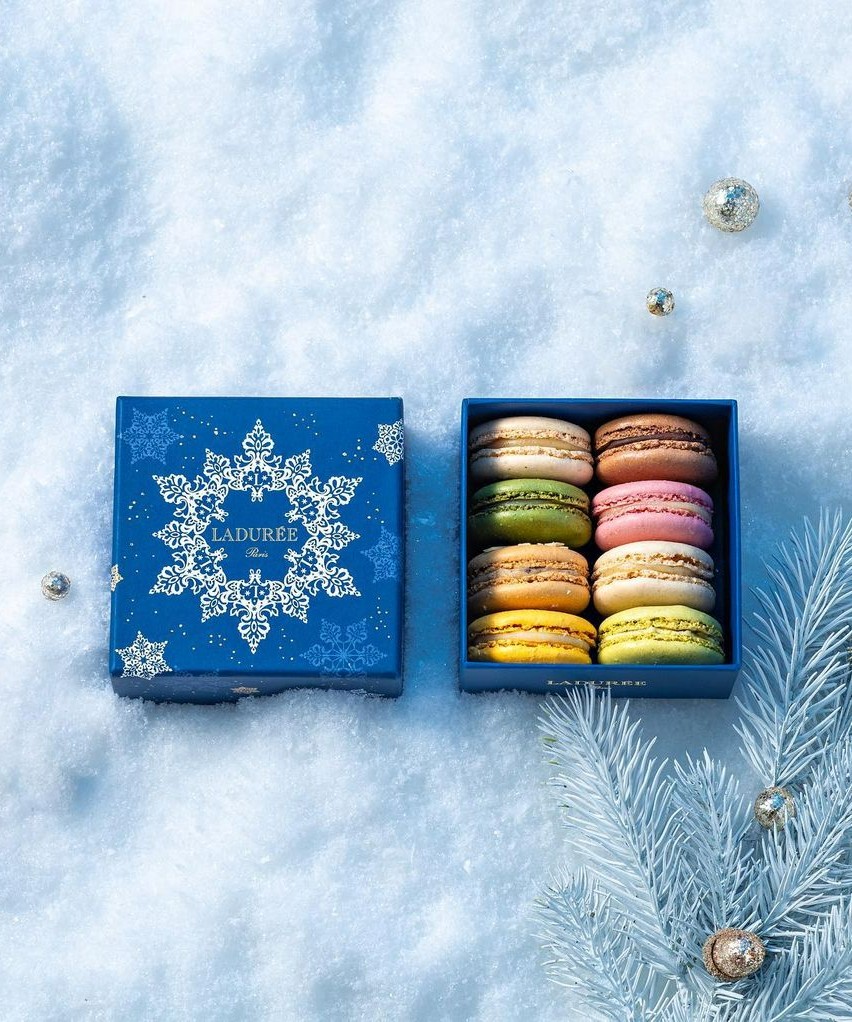 Close-up shot of an open, blue, holiday-themed box of macarons from Laudree.