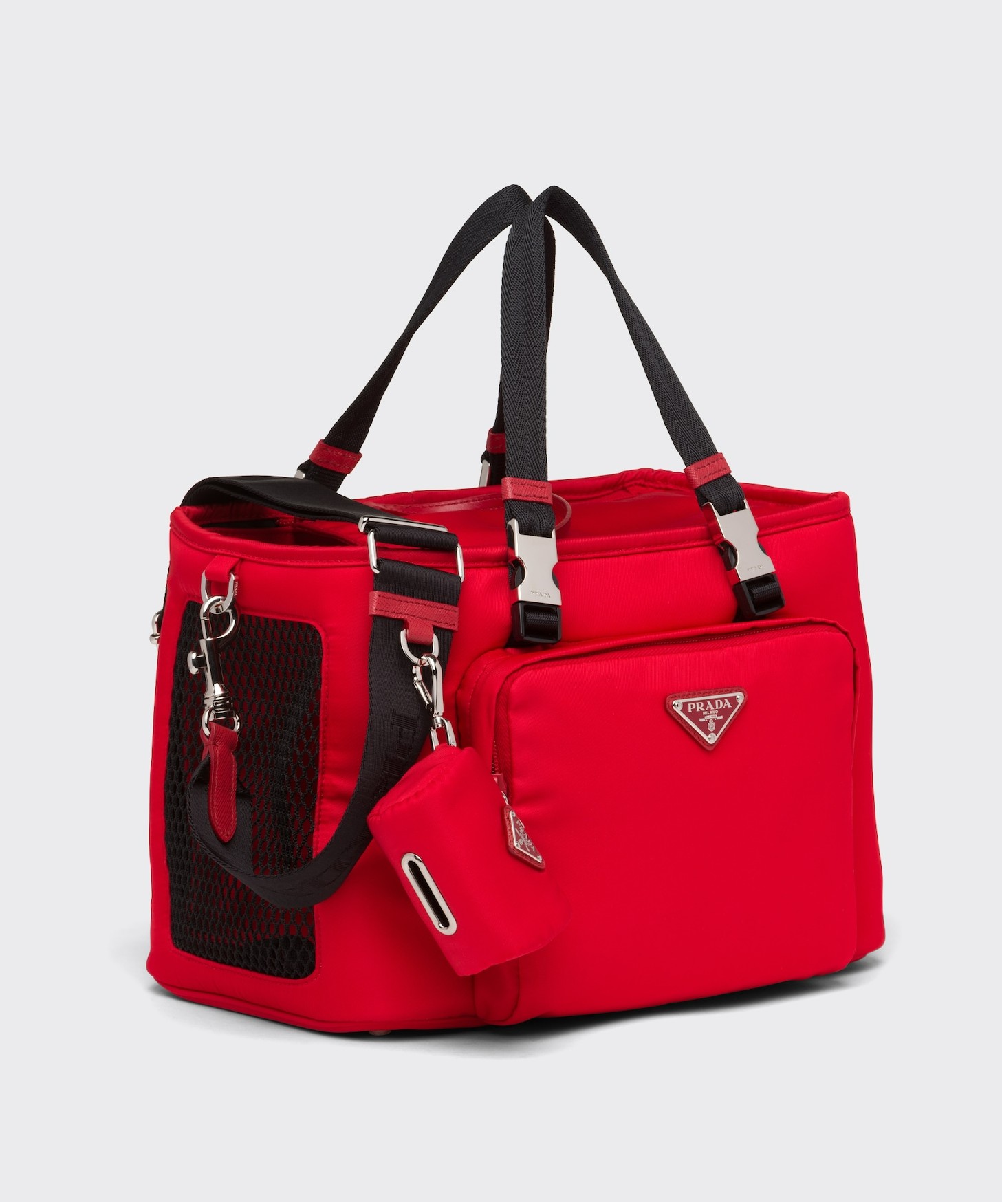 Red Nylon Prada bag decorated with the iconic triangle logo. It features woven nylon handles, a detachable adjustable woven nylon and leather shoulders strap with removable pet waste bag pouch.