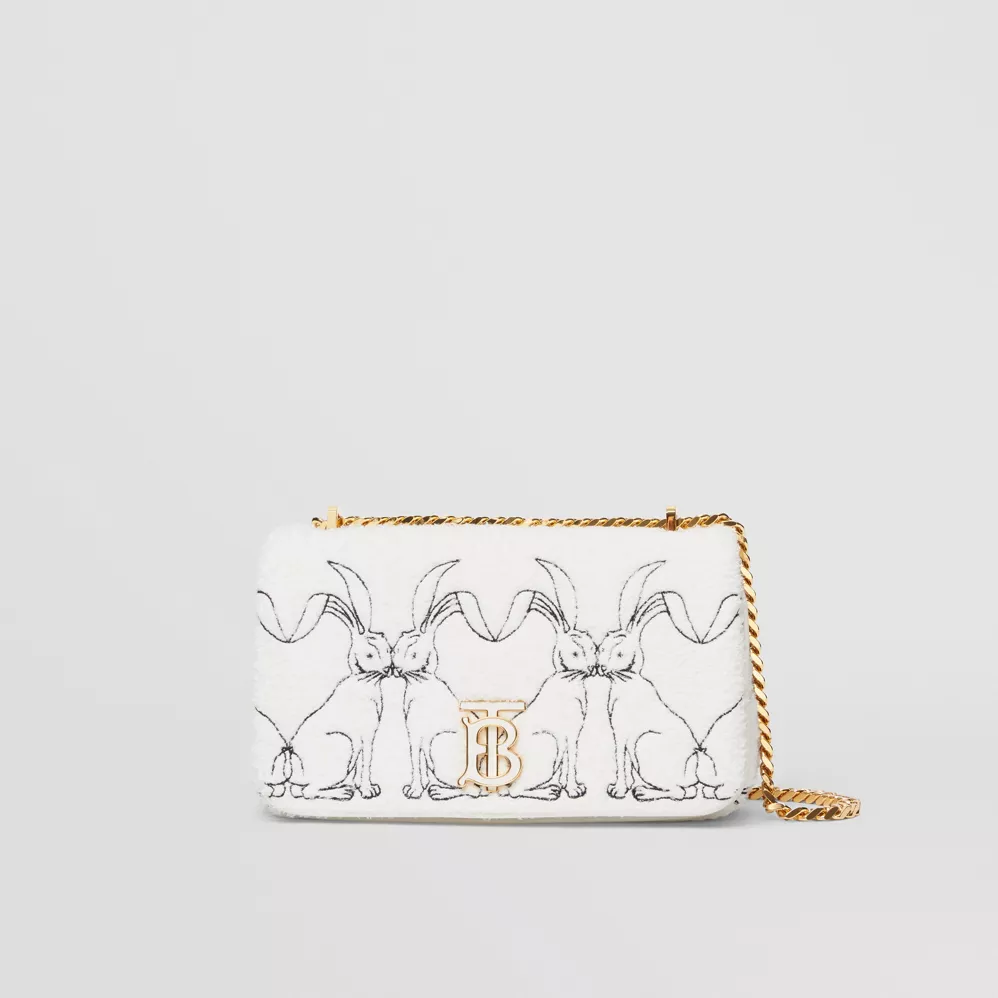 White Burberry handbag with illustrations of rabbits. The handbag also features gold hardware