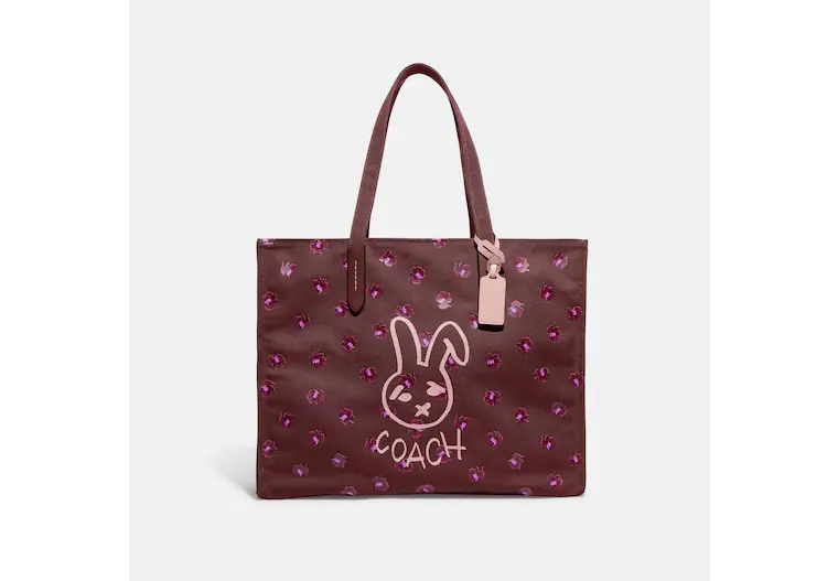 Image of a purple Coach tote with a bunny illustration on the front.