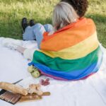 Two people wrapped up in a Pride flag