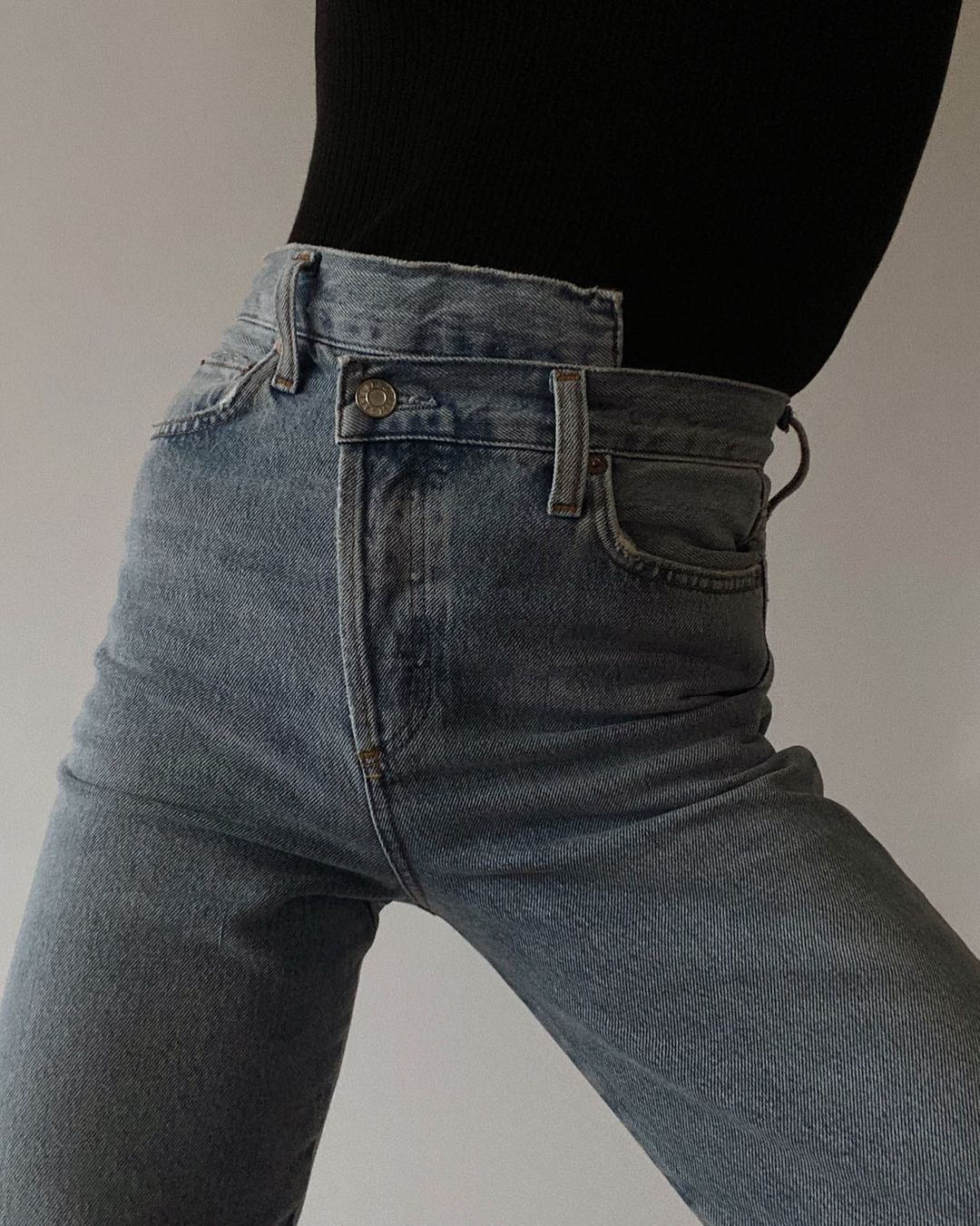 close-up image of a woman wearing asymmetrical jeans from Agolde
