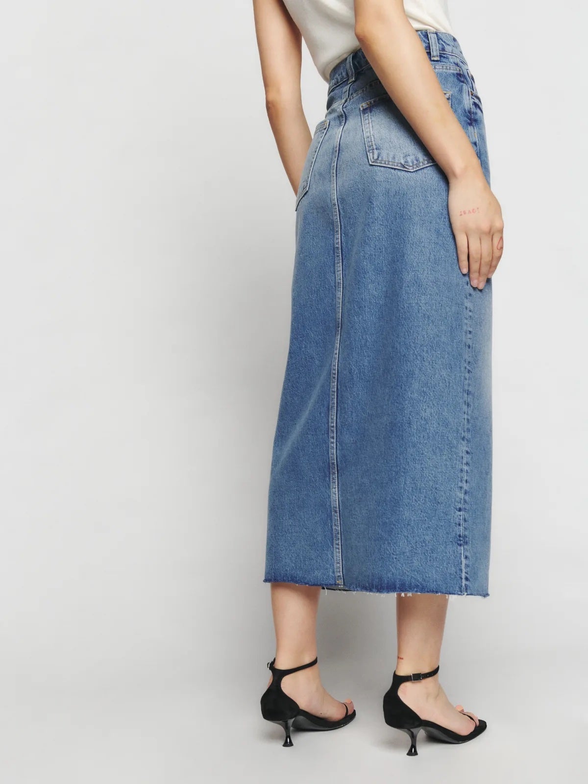 close-up image of a model wearing a denim maxi skirt from Reformation
