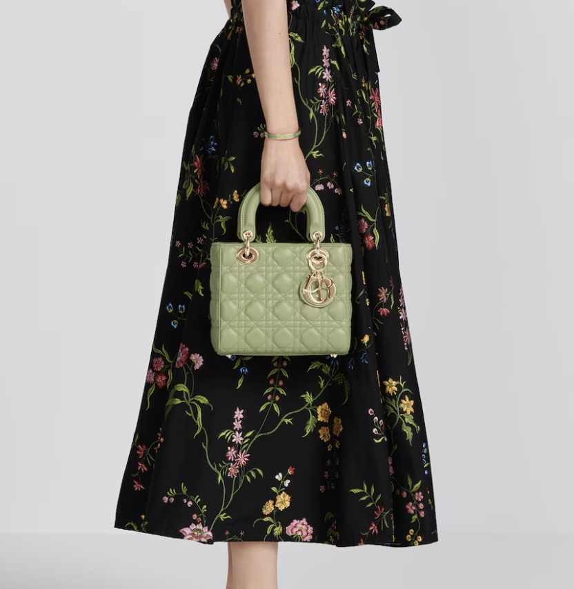 close-up image of a woman holding a green dior lady bag