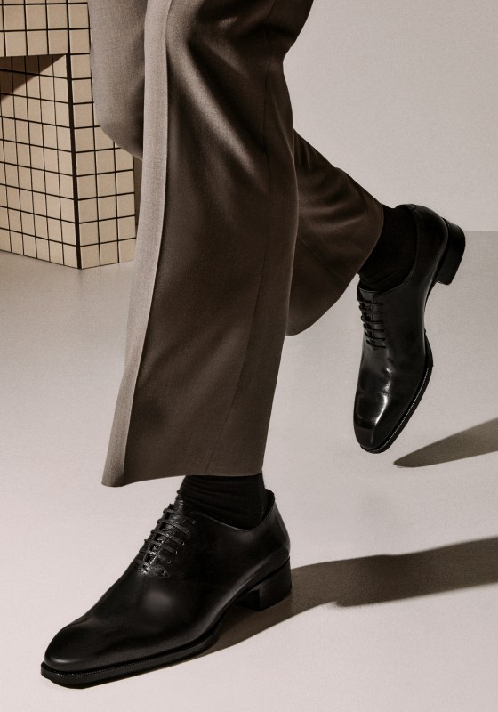 close-up image of man wearing classic black lace-up dress shoes