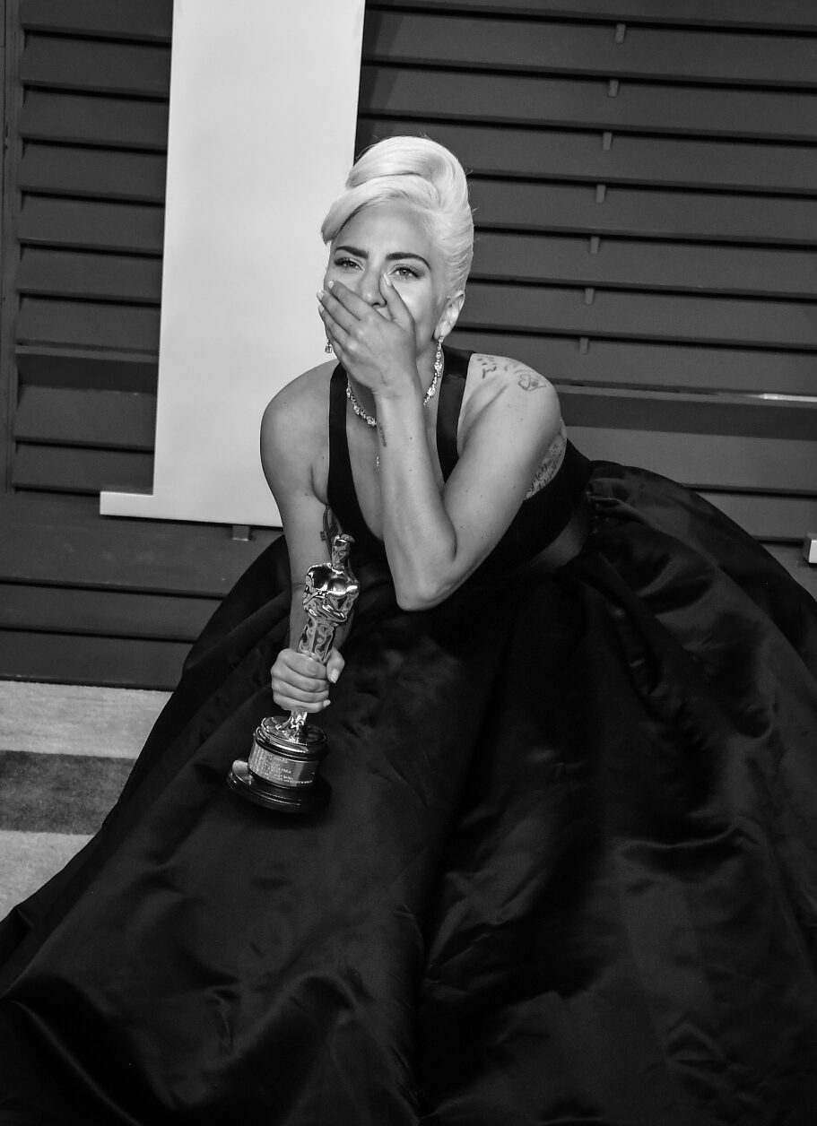 Black and white image of Lady Gaga holding an Oscar