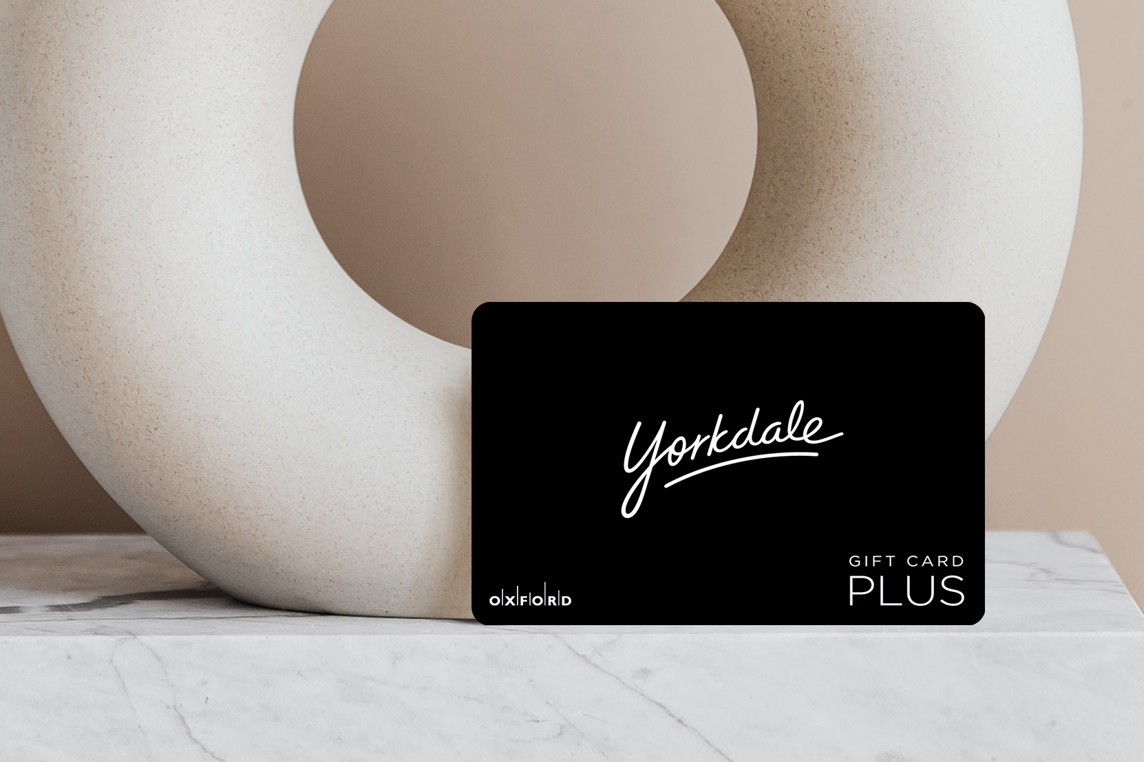 promotional image of a black yorkdale gift card in front of an oval ceramic vase