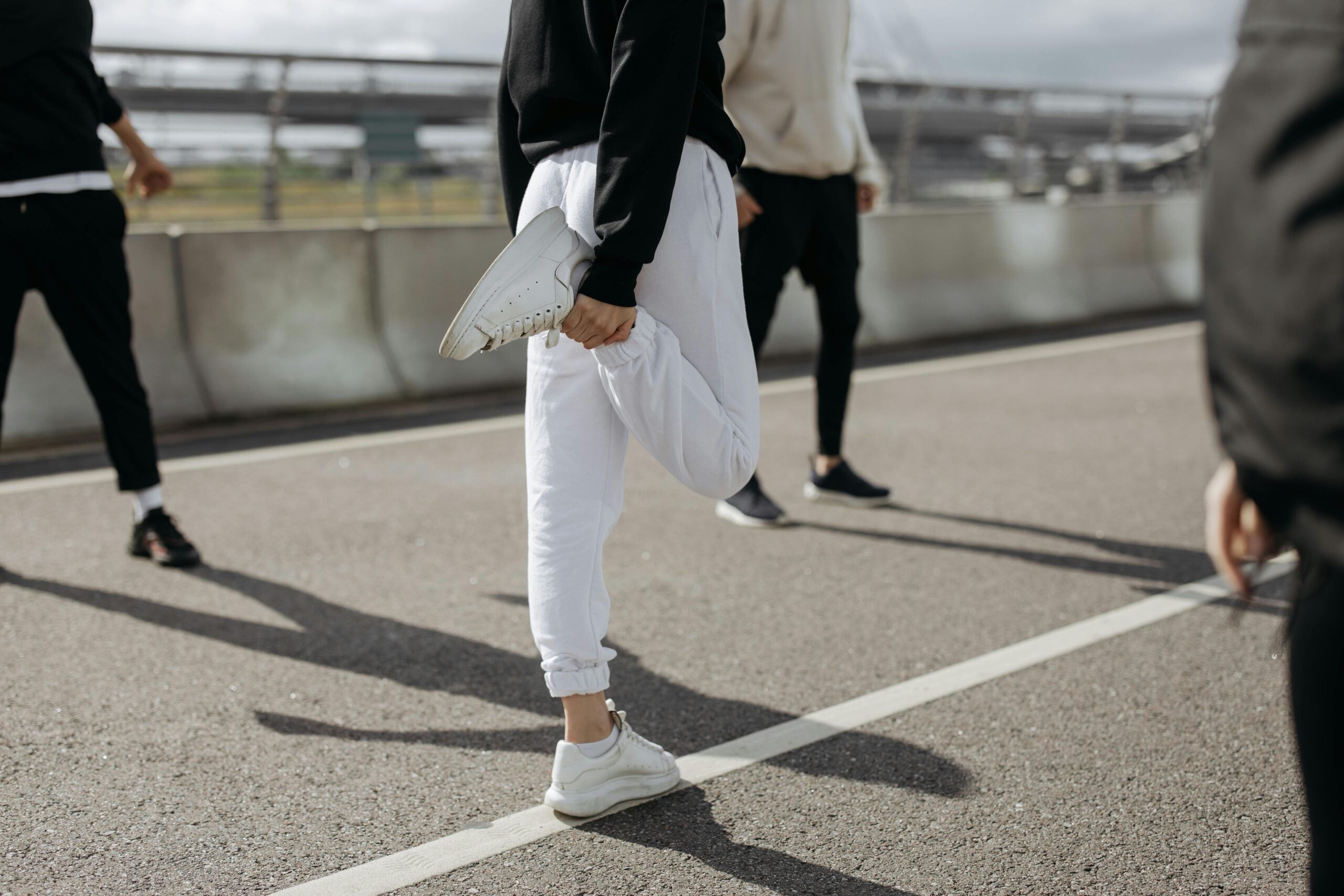 Person in white sweatpants stretching