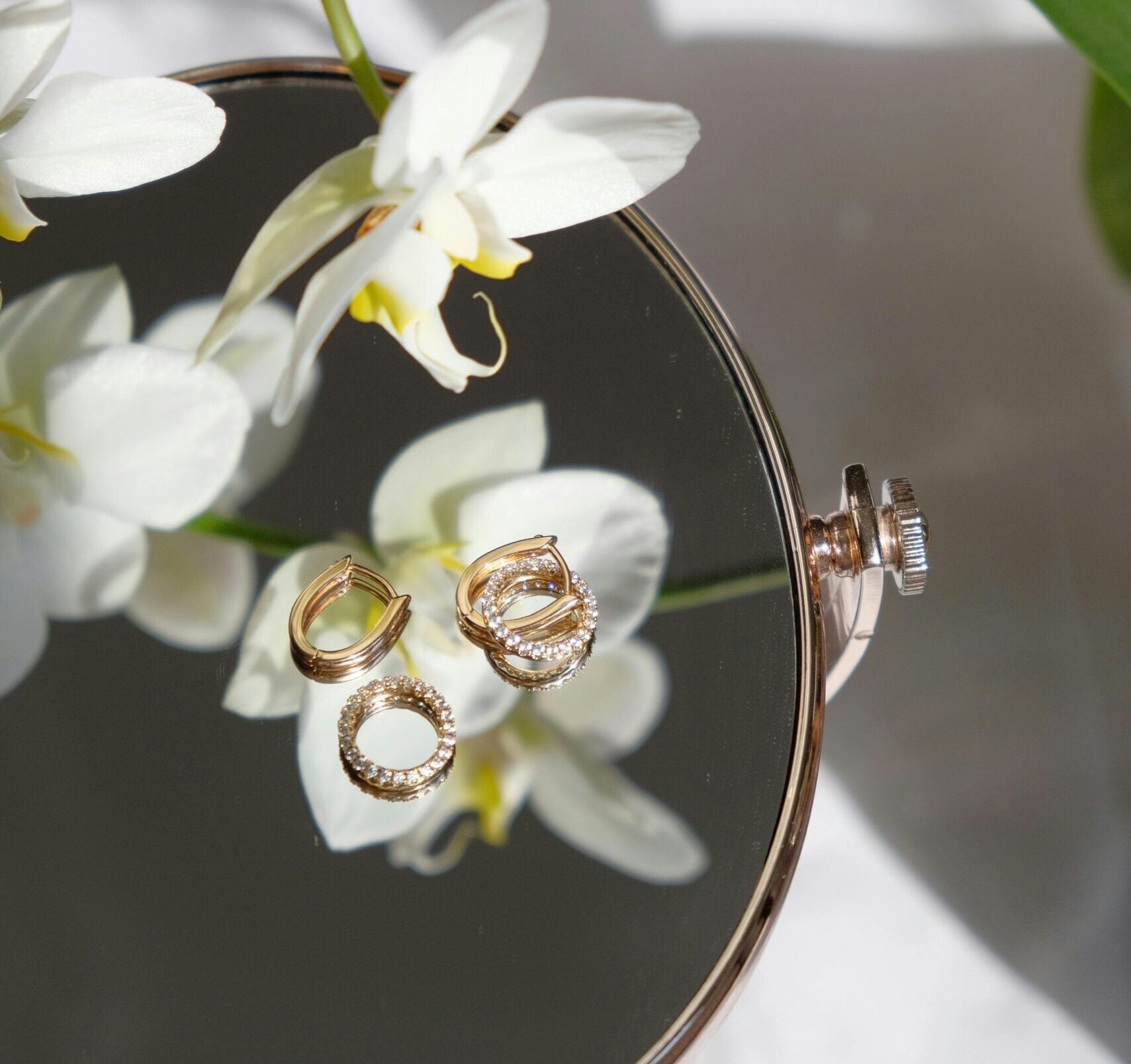 Jewellery on mirror with orchid flower