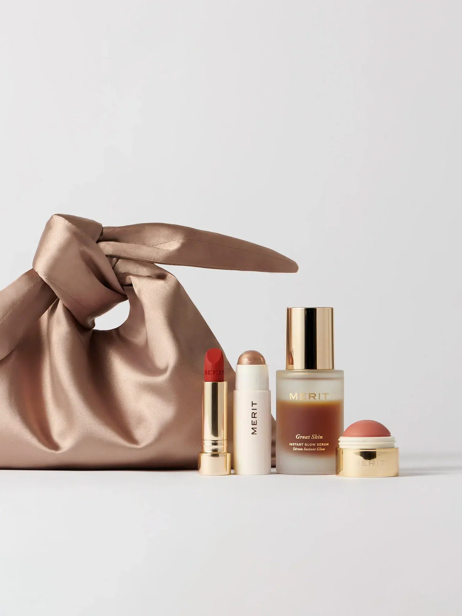 Beauty products and brown cream bag with a white backdrop